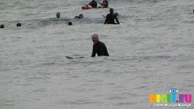 SX08865 Marijn sitting in surf at Porth Beach, Newquay